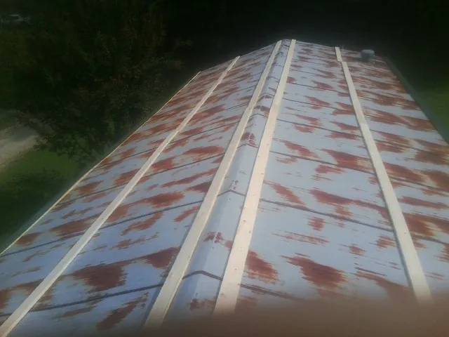 Rusted metal roof panels with new wood purlins before replacement — Storm Damage Roof Repair in Bradford by Roofing Brothers